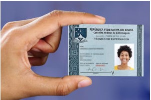 Pessoa segurando a carteira de identificação profissional de Técnico em Enfermagem emitida pelo Conselho Federal de Enfermagem (Cofen).