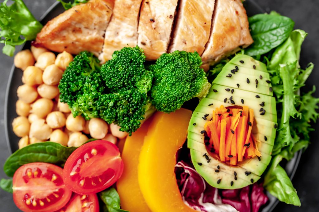 Prato colorido com vegetais, grão-de-bico, frango e abacate, ideal para fortalecer a pele e prevenir estrias.