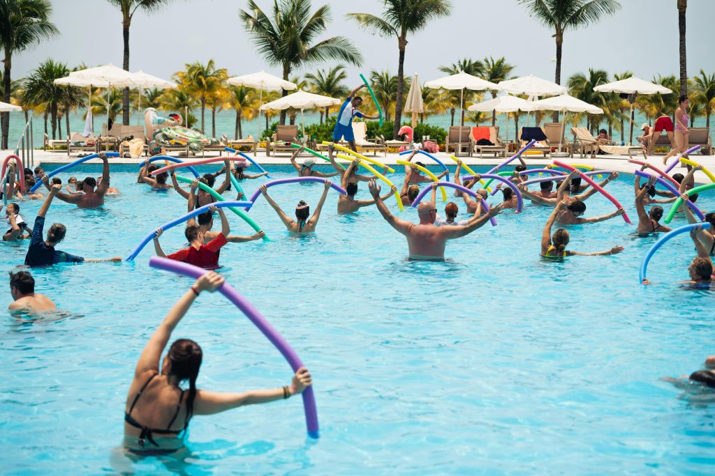 Grupo de pessoas praticando hidroginástica em piscina, representando atividade física para qualidade de vida na menopausa.