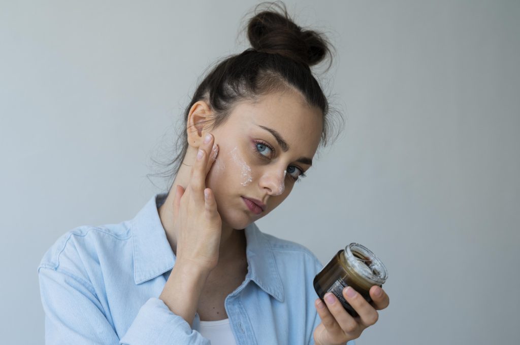 Mulher aplicando creme no rosto como parte do tratamento contra melasma, cuidado essencial para clarear e proteger a pele.