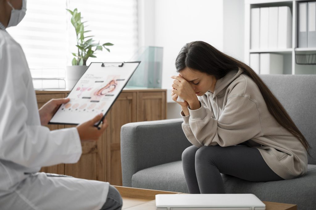 Mulher emocionada em consulta médica após perda gestacional recebe acolhimento e orientação