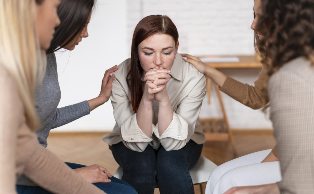 Mulher em luto recebe apoio e acolhimento de amigas durante recuperação após perda gestacional