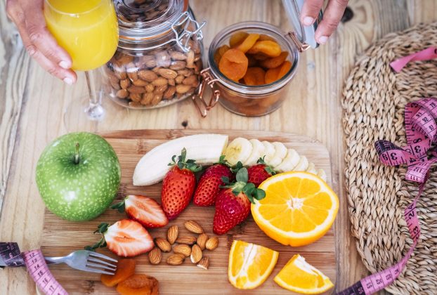 Frutas frescas, castanhas e suco natural em dieta equilibrada para emagrecer com saúde.