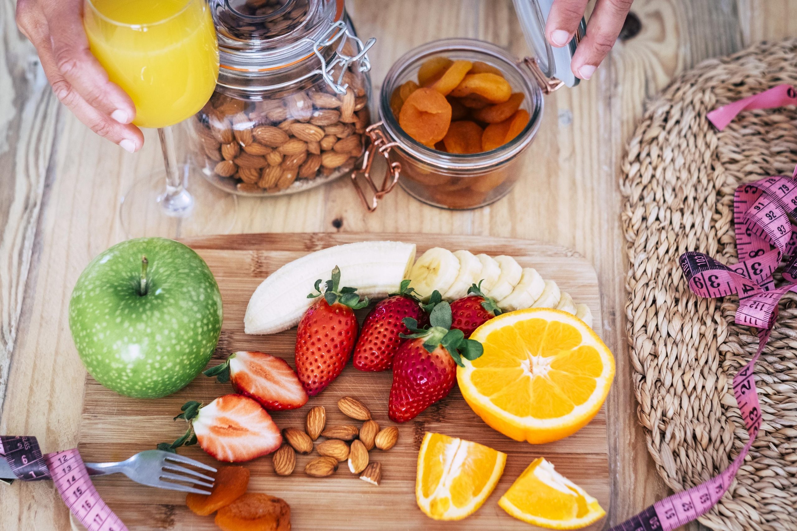 Frutas frescas, castanhas e suco natural em dieta equilibrada para emagrecer com saúde.