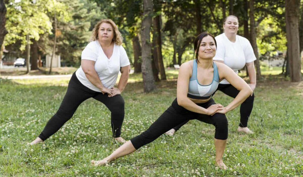Grupo de mulheres praticando exercícios ao ar livre, representando hábitos saudáveis para evitar a flacidez da pele ao emagrecer.